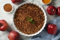 Tasty apple crisp in baking dish and ingredients on white marble table, flat lay Royalty Free Stock Photo