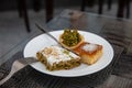 Tasty arabic sweet dessert with pistachios on white plate in typical local cafe in Doha City