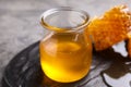 Tasty aromatic honey and combs on grey table, closeup