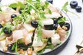 Tasty arugula salad with sweet pears, blueberries, roquefort cheese, smoked pork ham and crunchy walnuts. White kitchen table Royalty Free Stock Photo