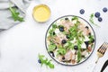 Tasty arugula salad with sweet pears, blueberries, roquefort cheese, smoked pork ham and crunchy walnuts. White kitchen table Royalty Free Stock Photo