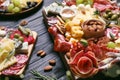 Tasty assorted appetizers served on black wooden table