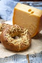 Tasty baked bagels with melted cheese and piece of aged Dutch Gouda cheese