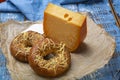 Tasty baked bagels with melted cheese and piece of aged Dutch Gouda cheese