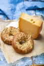 Tasty baked bagels with melted cheese and piece of aged Dutch Gouda cheese