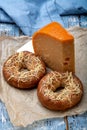 Tasty baked bagels with melted cheese and piece of aged Dutch Gouda cheese