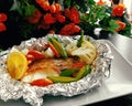 Tasty baked fish in foil on table close-up