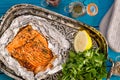 Tasty Baked Fish Salmon in Foil on Blue Table Royalty Free Stock Photo