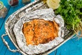 Tasty Baked Fish Salmon in Foil on Blue Table Royalty Free Stock Photo