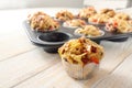 Tasty baked pizza muffins as finger food for a party from yeast dough, tomatoes, vegetables, sausage and cheese on a wooden table Royalty Free Stock Photo