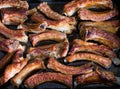 Tasty baked pork ribs in black baking tray. Full frame