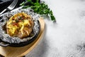 Tasty baked potato topped with cheddar cheese and chives. White background. Top view. Copy space