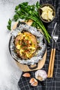 Tasty baked potato topped with cheddar cheese and chives. White background. Top view