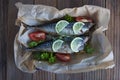 Tasty baked whole sea fishes on baking paper. Baked sea bream with lemon, herbs, tomatoes, spices on woode rustic background. Gril Royalty Free Stock Photo