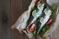 Tasty baked whole sea fishes on baking paper. Baked sea bream with lemon, herbs, tomatoes, spices on woode rustic background. Gril Royalty Free Stock Photo