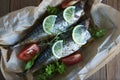 Tasty baked whole sea fishes on baking paper. Baked sea bream with lemon, herbs, tomatoes, spices on woode rustic background. Gril Royalty Free Stock Photo