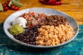 Tasty barbacoa burrito bowl, meat rice black beans sour cream guacamole and chopped vegetables