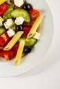 Tasty beautiful greek traditional greek or italian salad with vegetables and pasta on plate. Bright Background. Top View. Royalty Free Stock Photo