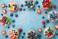 Tasty berry tartlets or cake with cream cheese and different berries around. Pastry dessert top view. Royalty Free Stock Photo