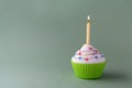 Tasty birthday cupcake with candle, on green background, with free space Royalty Free Stock Photo