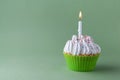 Tasty birthday cupcake with candle, on green background, with free space Royalty Free Stock Photo