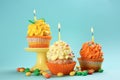 Tasty birthday cupcakes with burning candles on color background Royalty Free Stock Photo