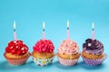 Tasty birthday cupcakes with burning candles on color background Royalty Free Stock Photo