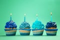 Tasty birthday cupcakes with burning candles on color background Royalty Free Stock Photo