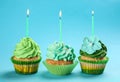 Tasty birthday cupcakes with burning candles on color background Royalty Free Stock Photo