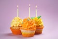 Tasty birthday cupcakes with burning candles on color background Royalty Free Stock Photo