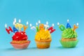 Tasty birthday cupcakes with candles on color background Royalty Free Stock Photo