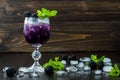 Tasty blackberry cocktail in wine glass with mint and ice on dark wooden table. Summer berry lemonade Royalty Free Stock Photo