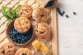 Tasty blueberry muffins with fresh berries and honey on table Royalty Free Stock Photo