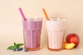 Tasty blueberry and peach milk shakes in glasses