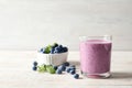 Tasty blueberry smoothie in glass, bowl