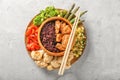 Tasty boiled wild rice with meat in bowl and vegetables on light table Royalty Free Stock Photo