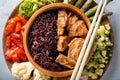 Tasty boiled wild rice with meat in bowl and vegetables on plate Royalty Free Stock Photo