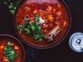 Tasty borscht on a dark background. Traditional Ukrainian food - beetroot soup with sour cream, parsley and pork ribs Royalty Free Stock Photo