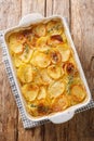 Tasty boulangere cooked slowly in the oven in vegetable stock until deliciously soft closeup in the baking dish. Vertical top view