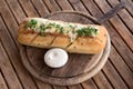 Tasty bread with garlic, cheese and herbs on wooden table. Royalty Free Stock Photo