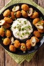 Tasty breaded fried olives with almonds close-up and creamy sauce. Vertical top view