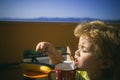 Tasty breakfast. A child eats a milkshake on a terrace of an apartment near the sea. Royalty Free Stock Photo