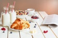 Tasty breakfast with croissant, oat flakes, berries and milk on the white wooden table Royalty Free Stock Photo