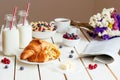 Tasty breakfast with croissant, oat flakes, berries and milk on the white wooden table Royalty Free Stock Photo