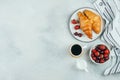 Tasty breakfast food concept. Coffee, croissants, strawberry and cherry for breakfast. Top view with copy space