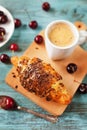 Tasty breakfast with fresh croissant, coffee and cherries on a wooden table Royalty Free Stock Photo