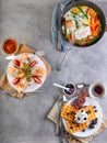 Tasty breakfast. Scrambled eggs in a pan, sandwiches with straw and cheese and Belgian waffles on a wooden white Royalty Free Stock Photo