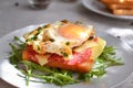 Tasty breakfast. Toast with egg, cheese and sausage. Sandwich in a white plate with arugula. Light background. Closeup Royalty Free Stock Photo