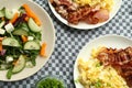 Tasty brunch. Delicious scrambled eggs, bacon and salad served on table, flat lay Royalty Free Stock Photo