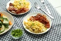 Tasty brunch. Delicious scrambled eggs, bacon and salad served on white table Royalty Free Stock Photo